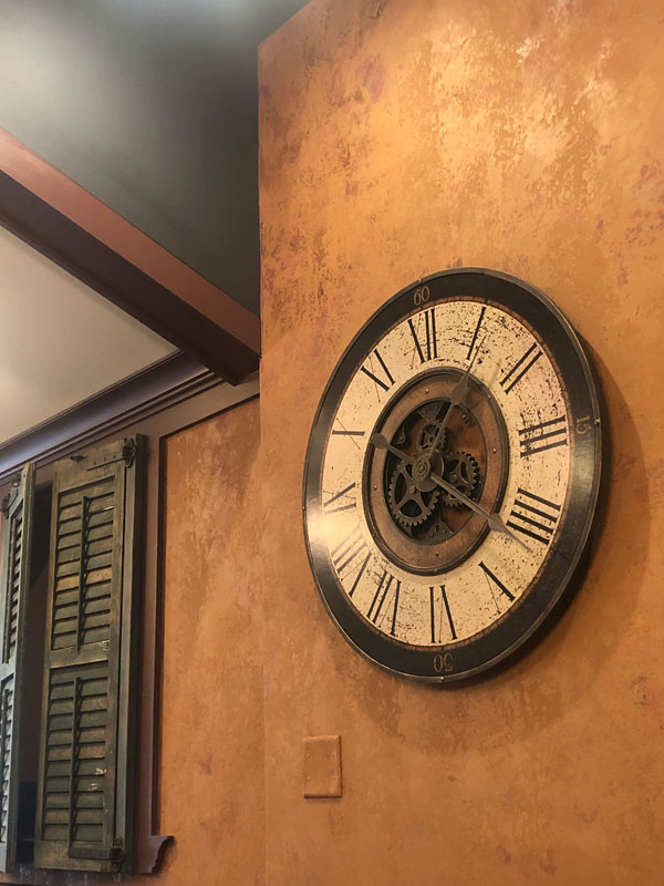 Clock on wall and green cast ceiling