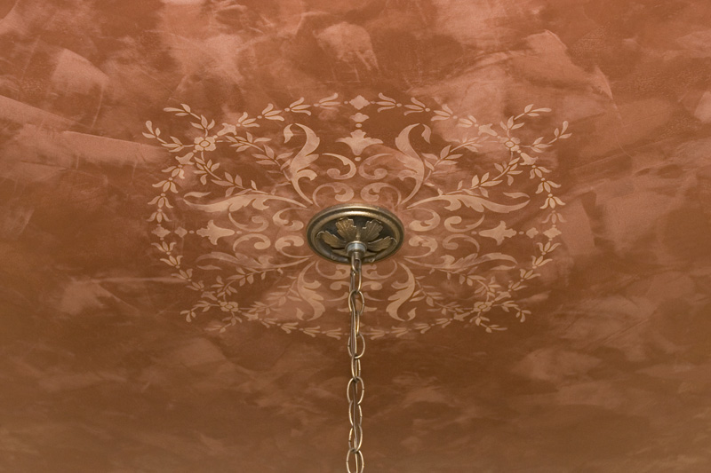 The light of a chandelier dances on LusterStone with a stenciled ornament.