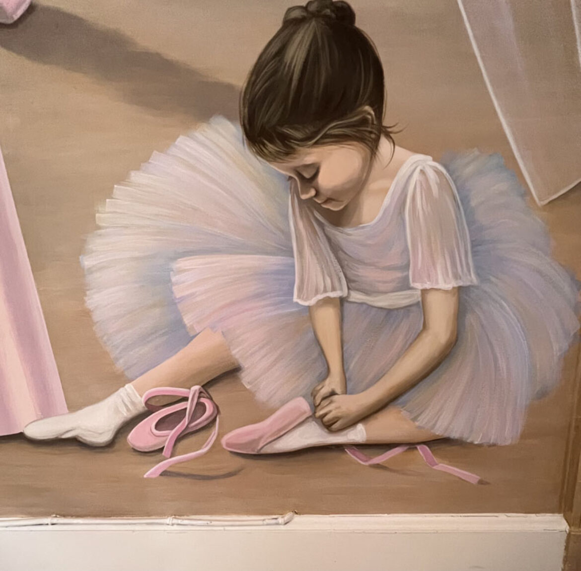 Little ballerina putting on her toe shoes