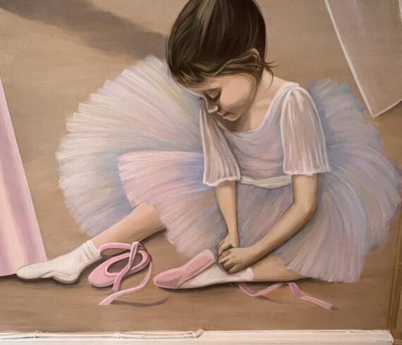 Little ballerina putting on her toe shoes